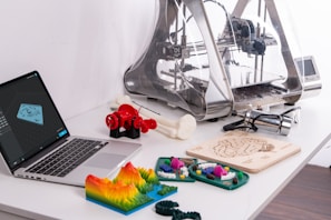MacBook Pro beside 3D printer