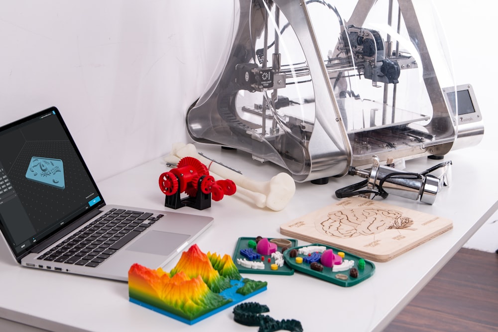 MacBook Pro beside 3D printer
