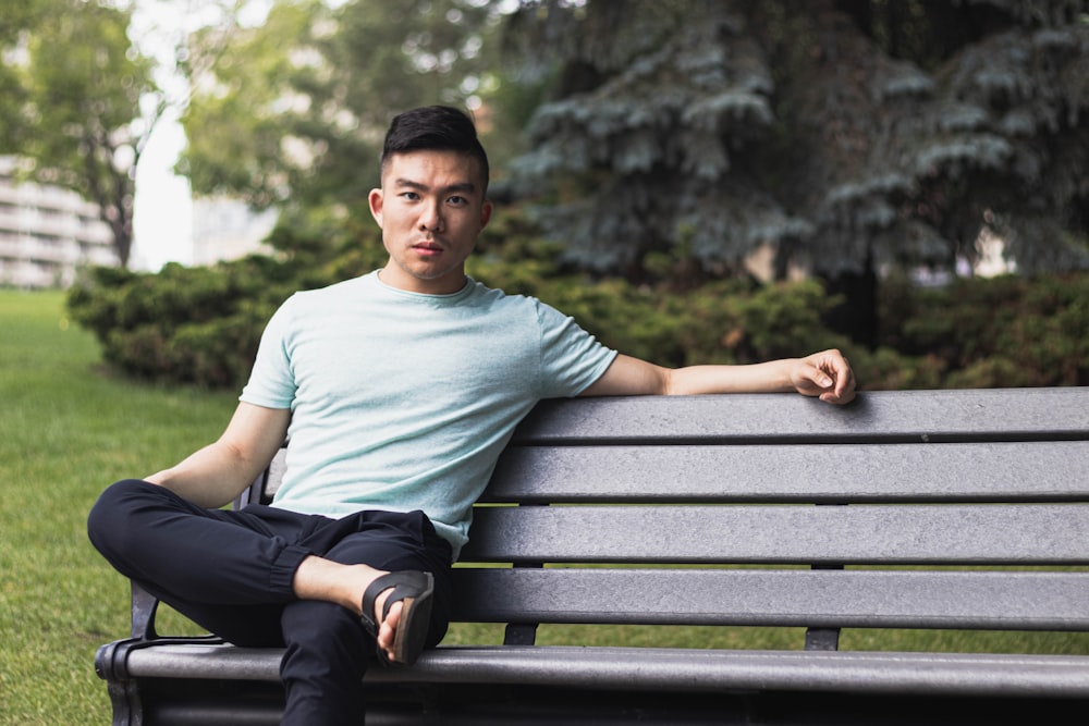 a man sitting on a bench in a park