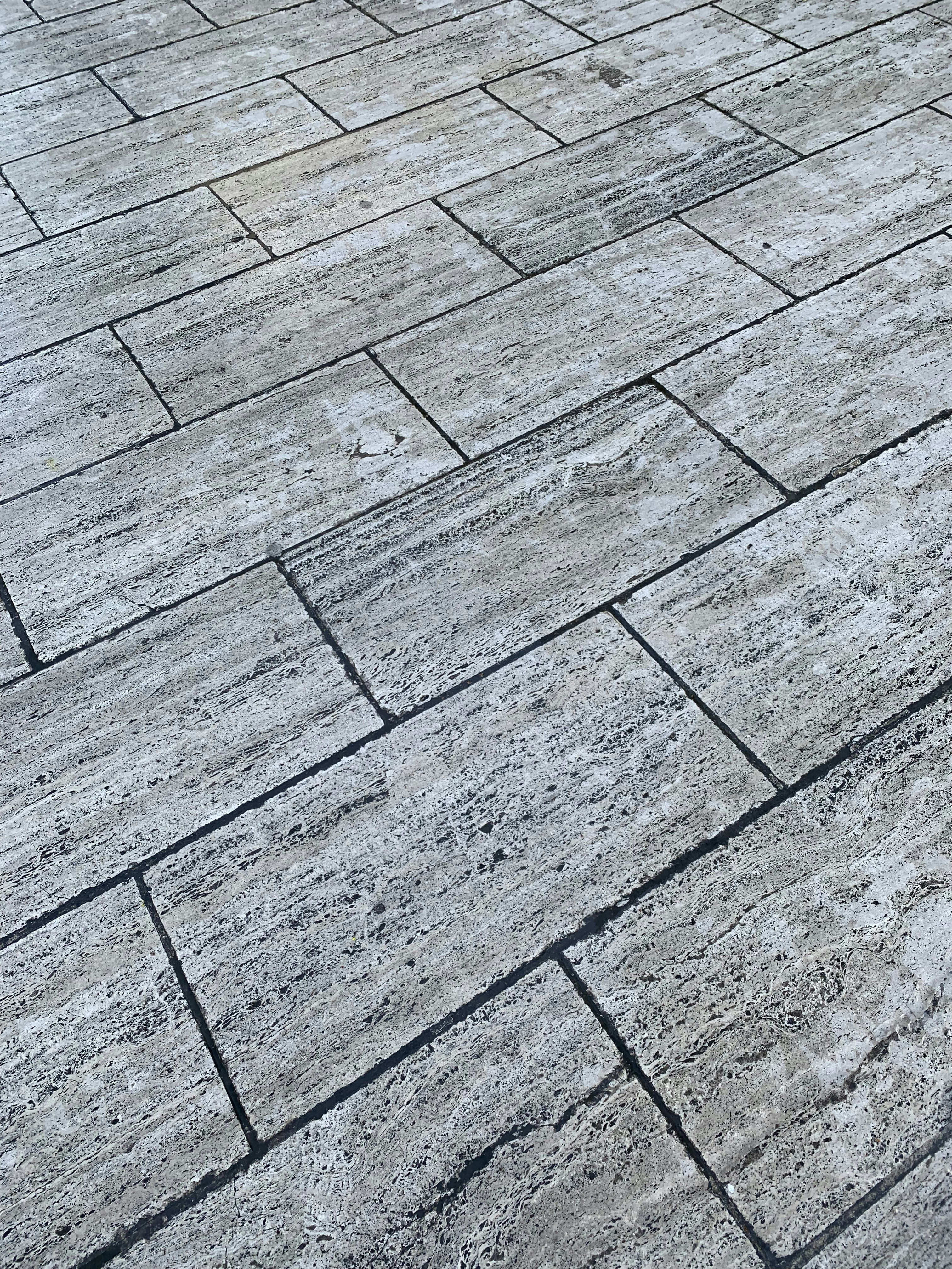 Sunlit outdoor terrace with textured anti-slip grey stone tiles and bright natural daylight