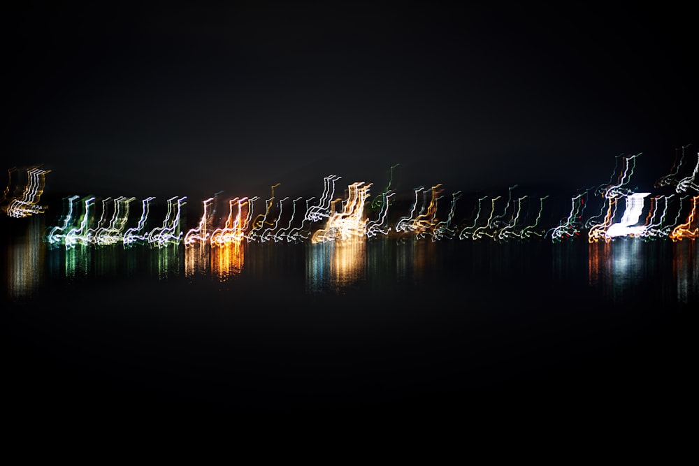 a long line of lights reflecting in the water