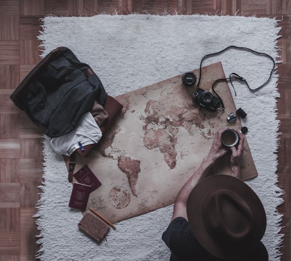 person holding mug sitting beside map