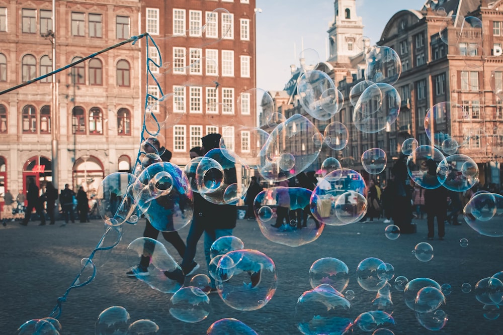 a group of people standing in front of a bunch of bubbles