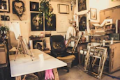 An artist’s studio with canvases and paintbrushes scattered around.