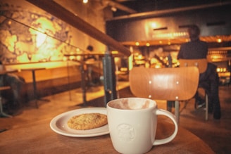 a cup of coffee and a cookie on a table