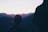 a person standing in front of a mountain at sunset
