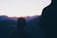 a person standing in front of a mountain at sunset