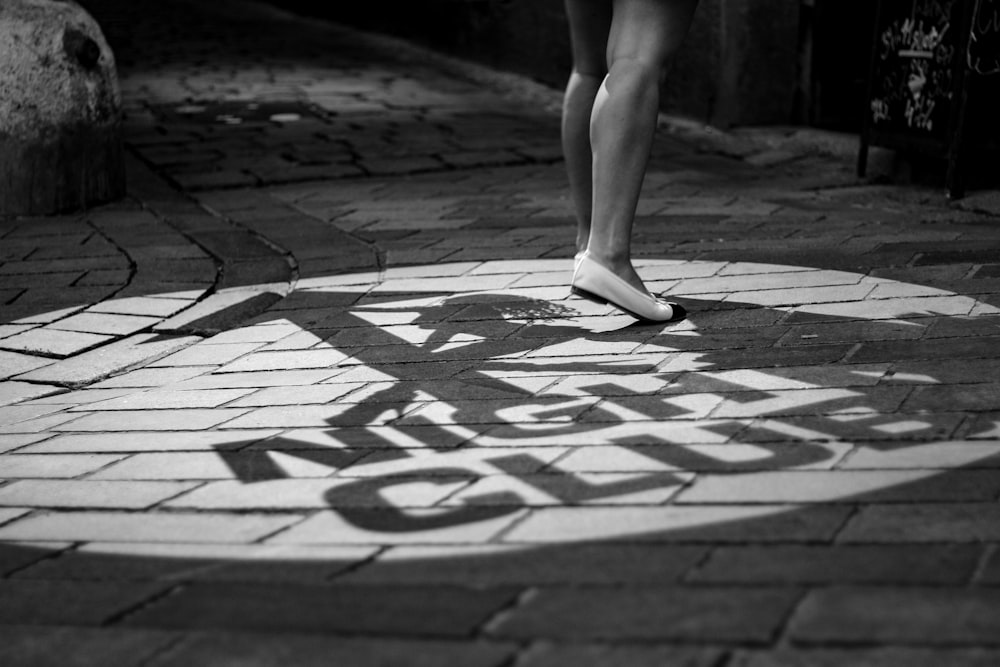 woman wearing flats standing on brick pavement