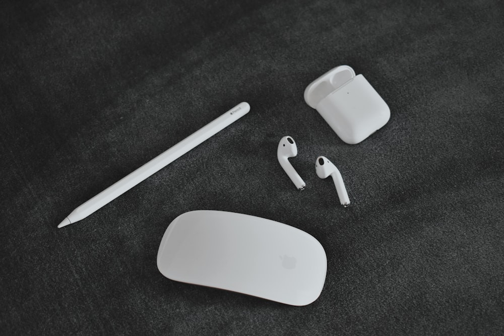 a pair of ear buds, a pair of headphones, and a white case