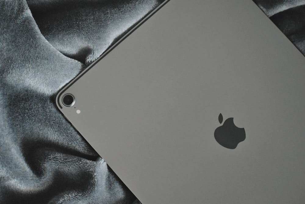 silver Apple iPad on grey textile