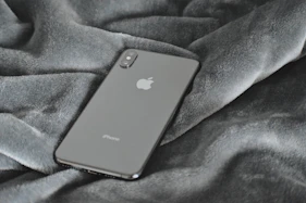 A sleek smartphone resting on a clean white surface with soft blue accents.