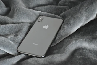 A sleek smartphone resting on a clean white surface with soft blue accents.