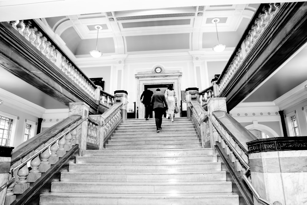 grayscale photography of man waking on stairs