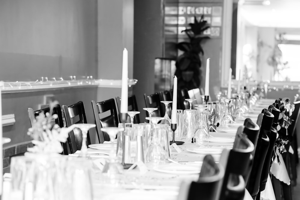 grayscale photography of wine glasses on table