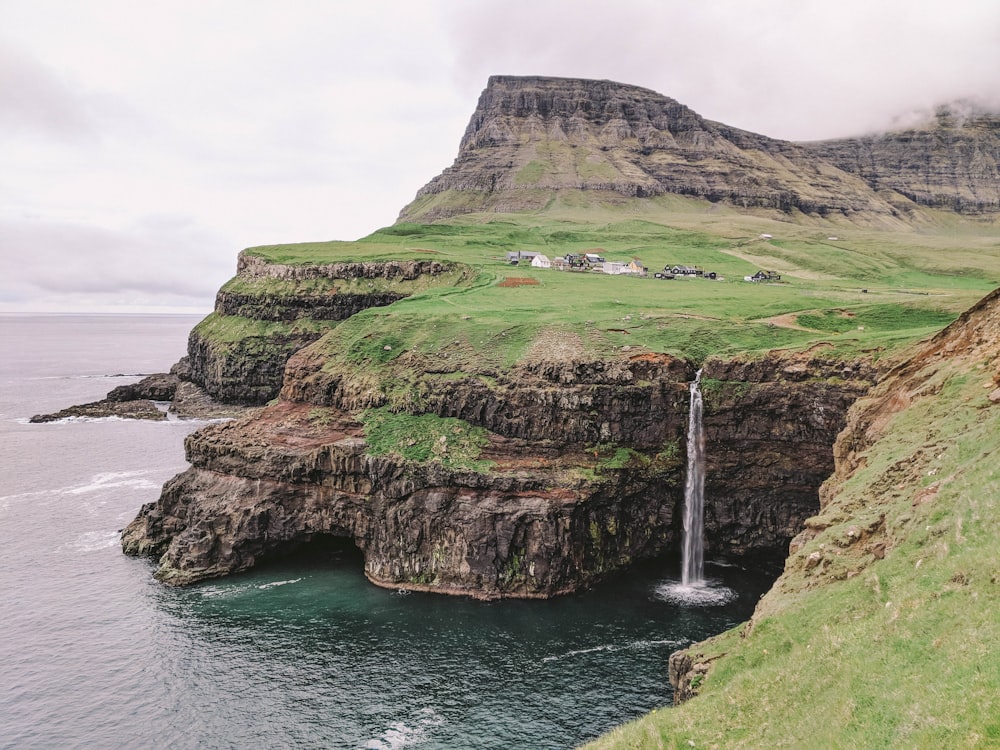 a small waterfall in the middle of a large body of water