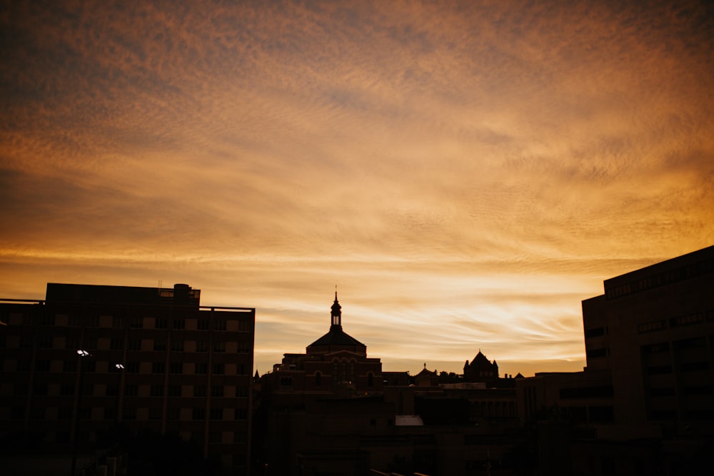 Una vista del tramonto di un edificio con un campanile in lontananza