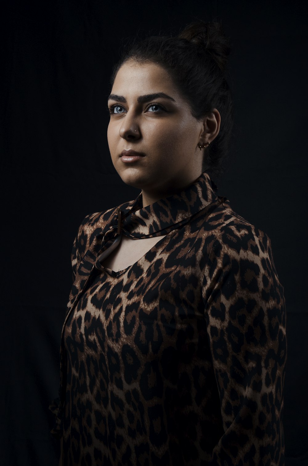 a woman in a leopard print shirt posing for a picture