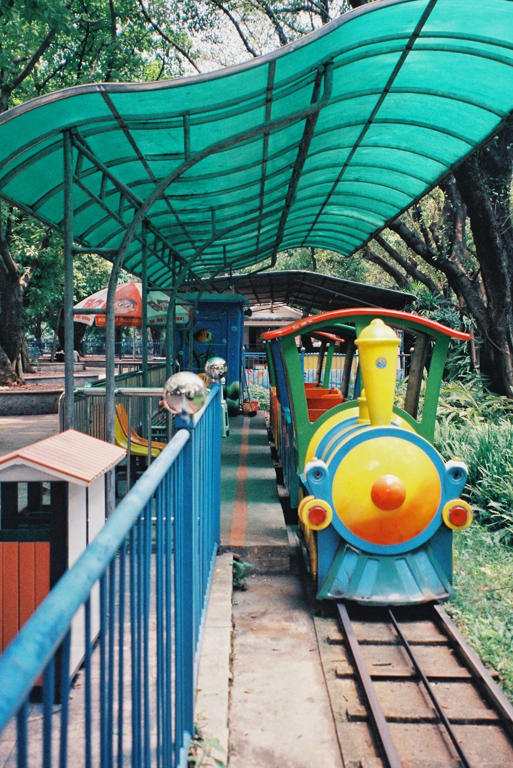 a small train on a track under a canopy