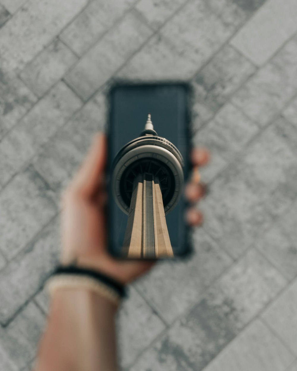 Person, die CN Tower bedruckte Handyhülle hält