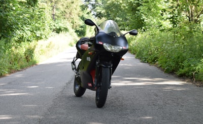 A powerful black sport motorcycle leaning on a winding mountain road at sunset.