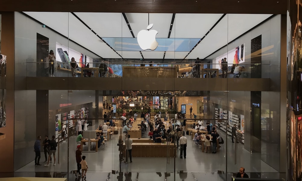 a group of people standing inside of an apple store