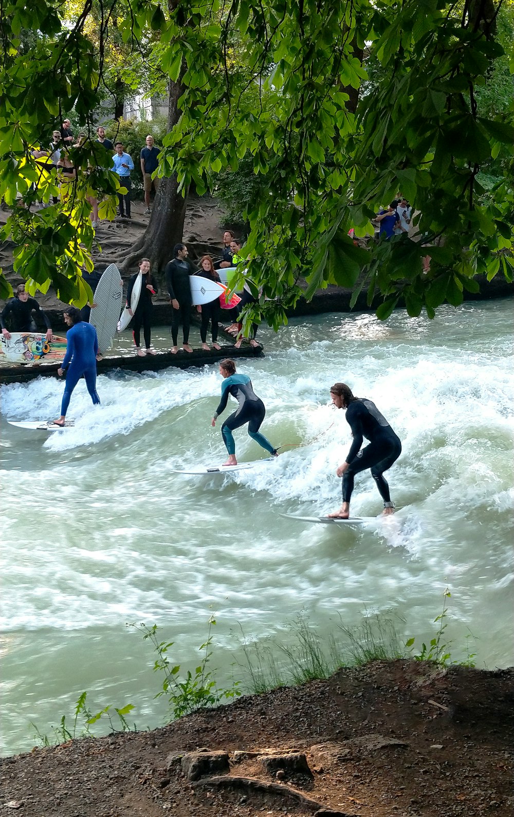 trois personnes surfant dans l’eau pendant la journée