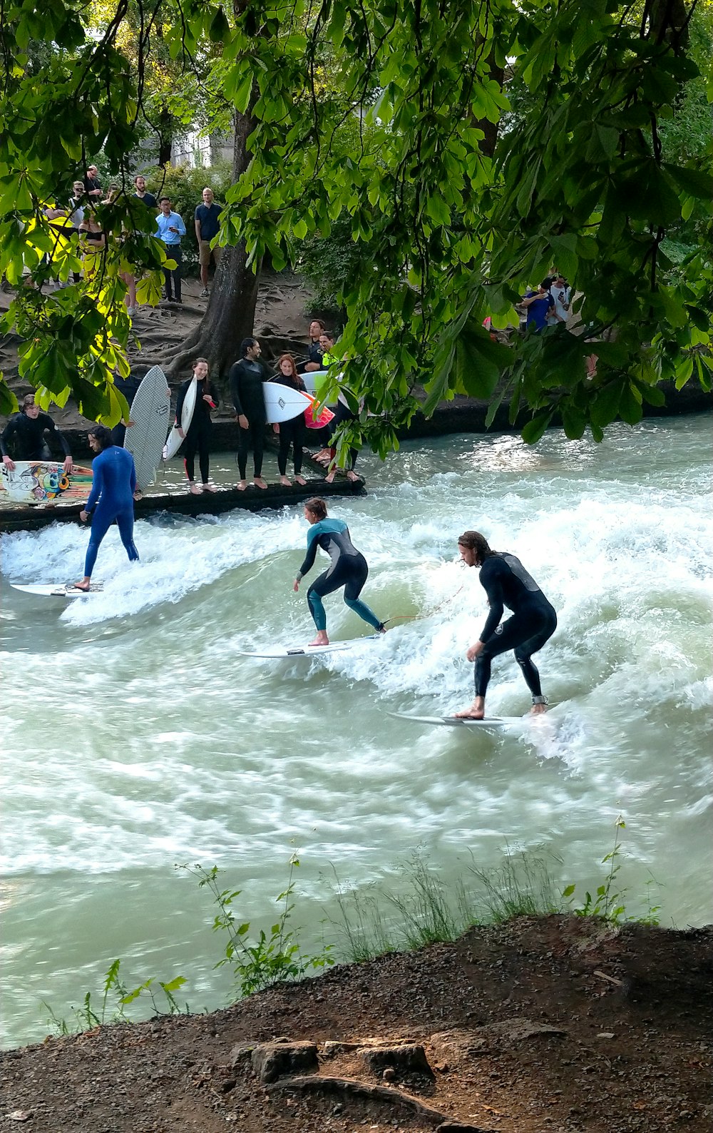 three person surfing in water during daytime