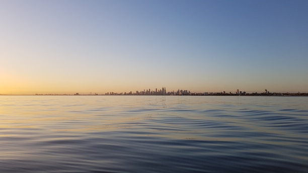 A serene landscape photograph of Hong Kong's skyline at sunset.