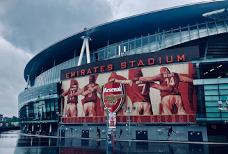 a man standing in front of the emirates stadium