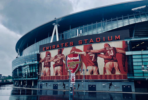 a man standing in front of the emirates stadium