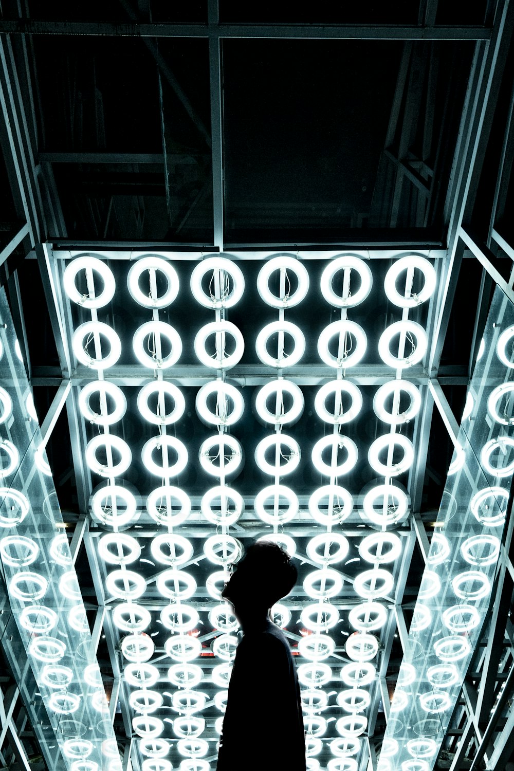 a person standing in front of a display of lights