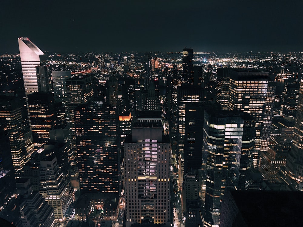 a view of a city at night from the top of a skyscraper