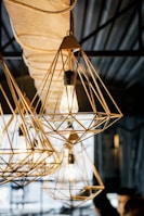 Minimalist industrial workshop with metal lamps in various stages of assembly.