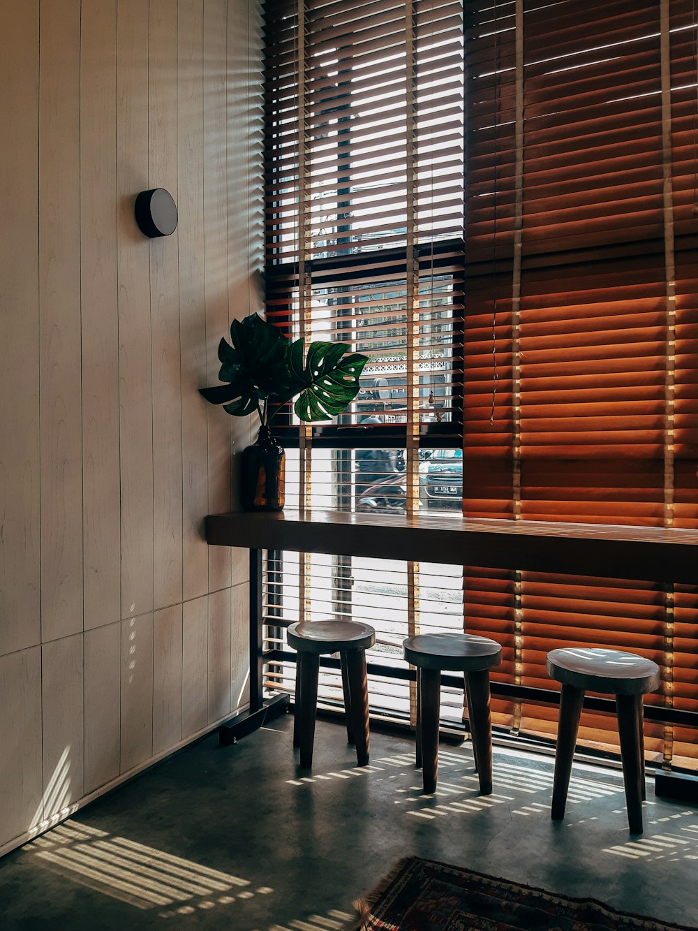 three stools under table with plant