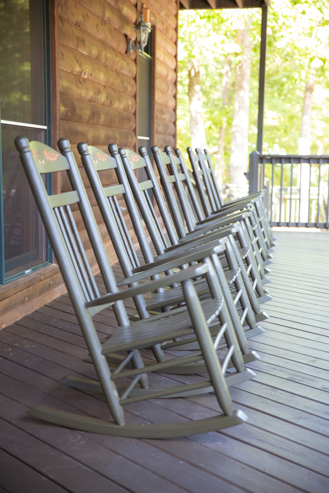 line of gray wooden rocking chairs on porch