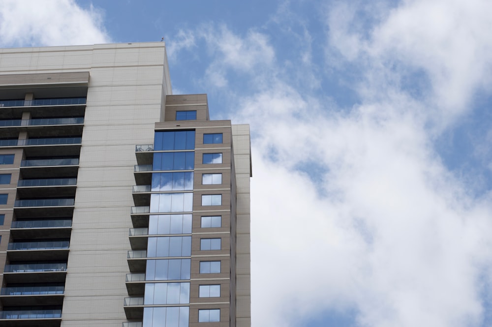 white and brown building across white clouds