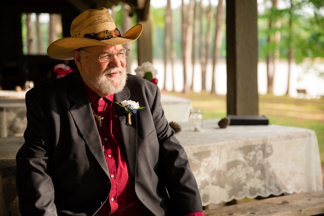 man in black blazer sitting on wooden bench