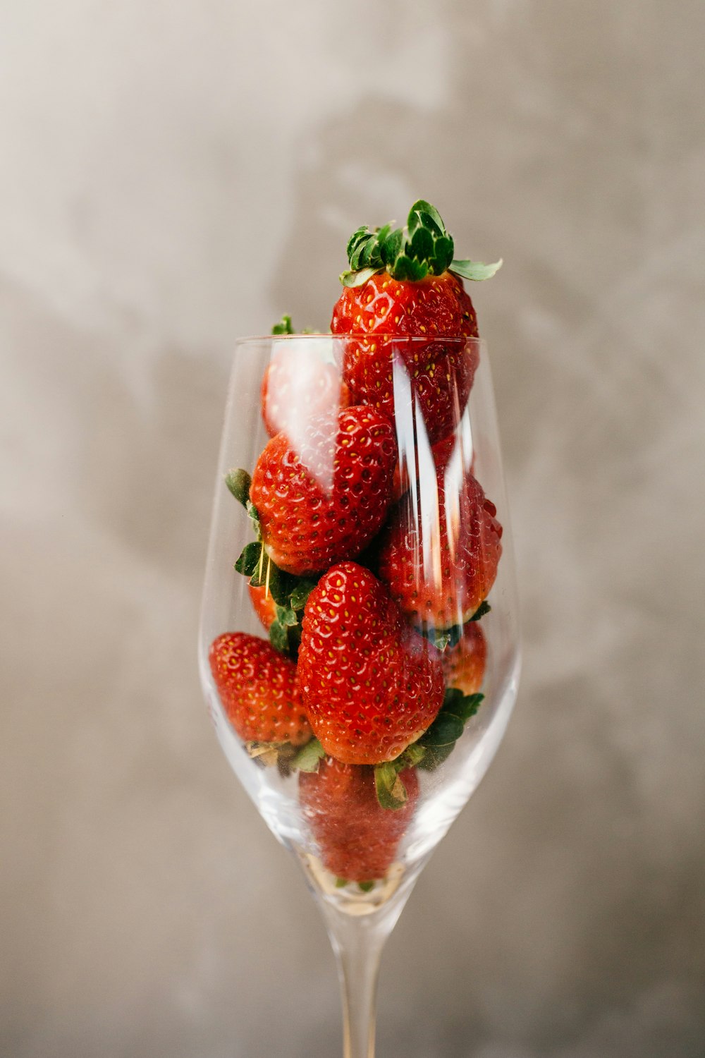 a glass filled with strawberries on top of a table