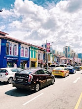 A vibrant street scene in Buenos Aires with various cars driving past iconic buildings under a clear sky.