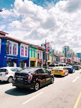 A vibrant street scene in Buenos Aires with various cars driving past iconic buildings under a clear sky.