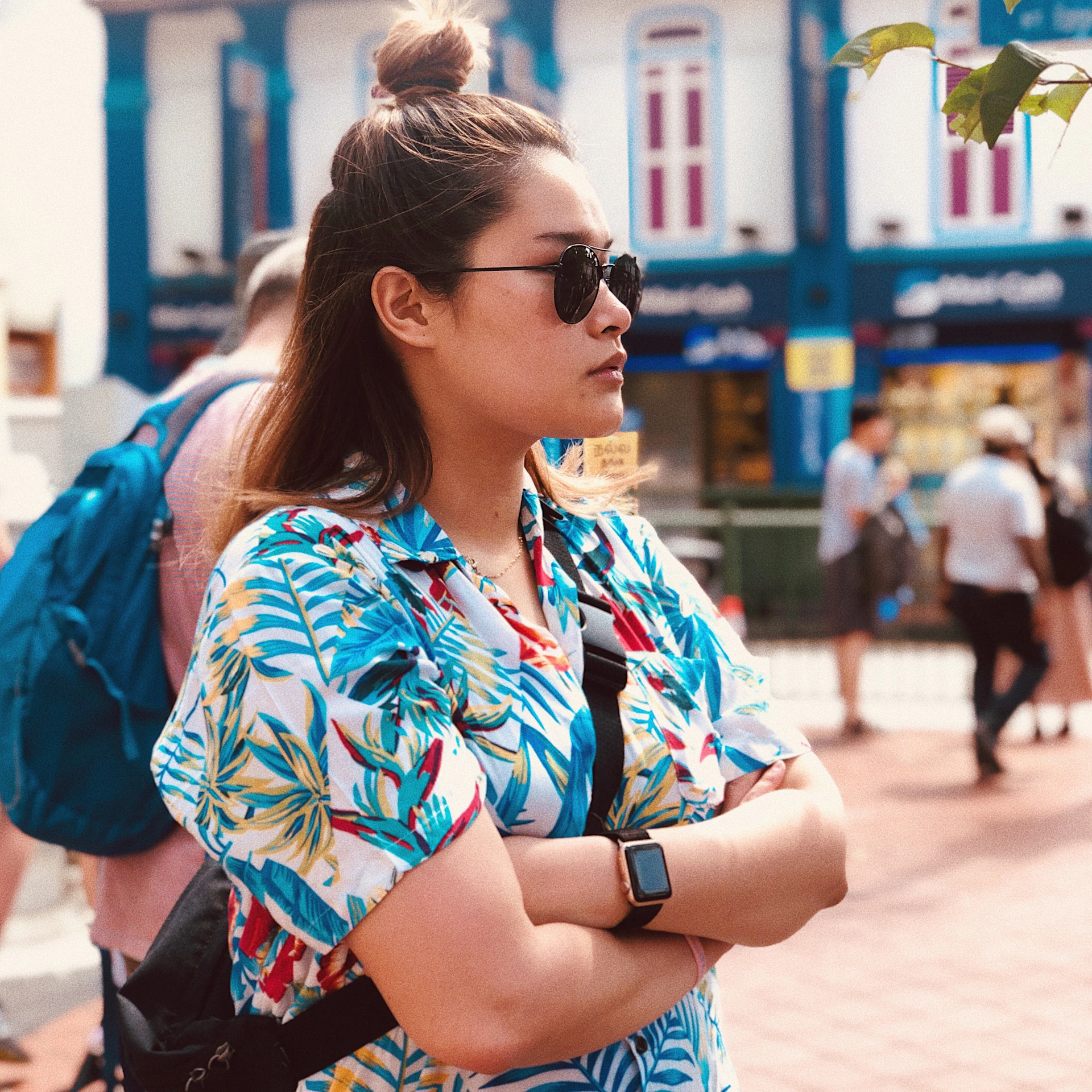 A vibrant street scene featuring a young woman in casual chic clothing and bold accessories, smiling and enjoying the day.