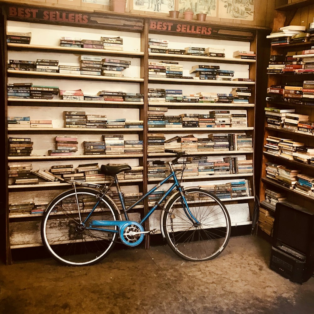 a blue bicycle parked in front of a book store