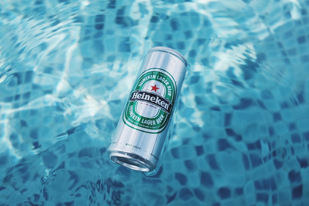 Lattina di bevanda Heineken che galleggia sull'acqua