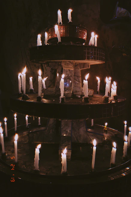Softly lit scene of a ritual space with burgundy candles and delicate art objects