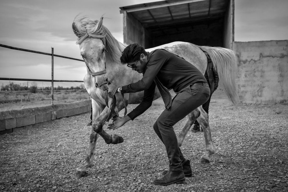 grayscale photography of man and horse