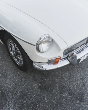 Side view of a white car with a perfectly restored bumper after kaporta service.