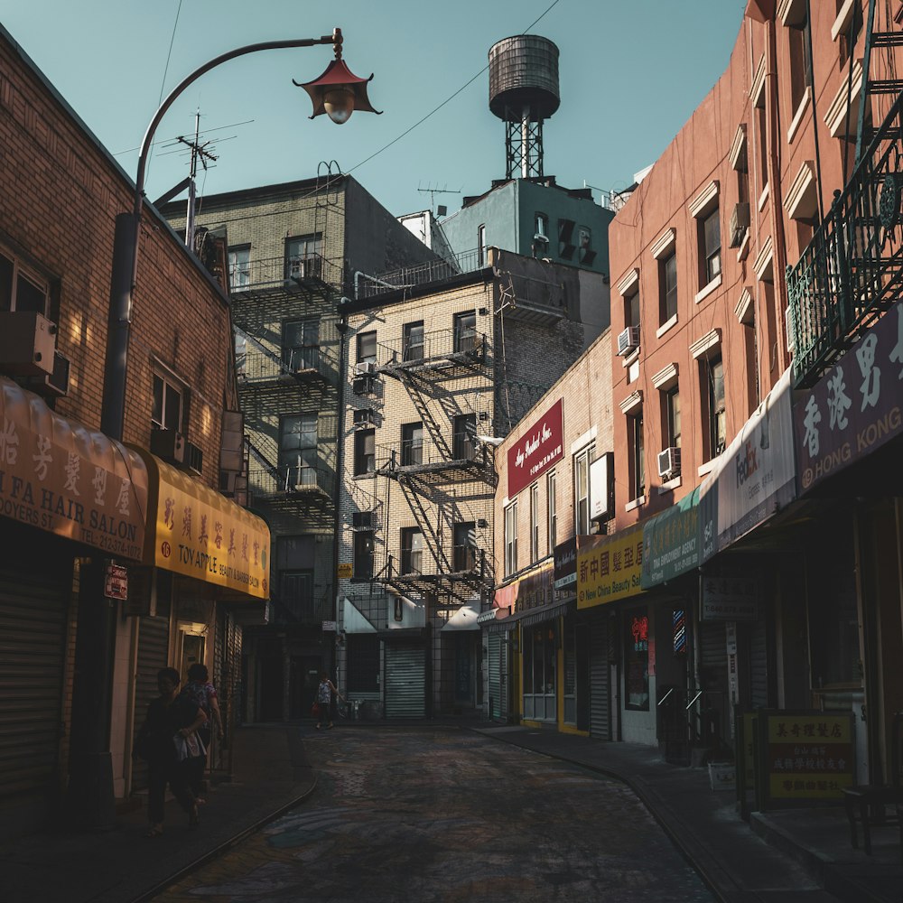 woman carrying toddler walking on alley