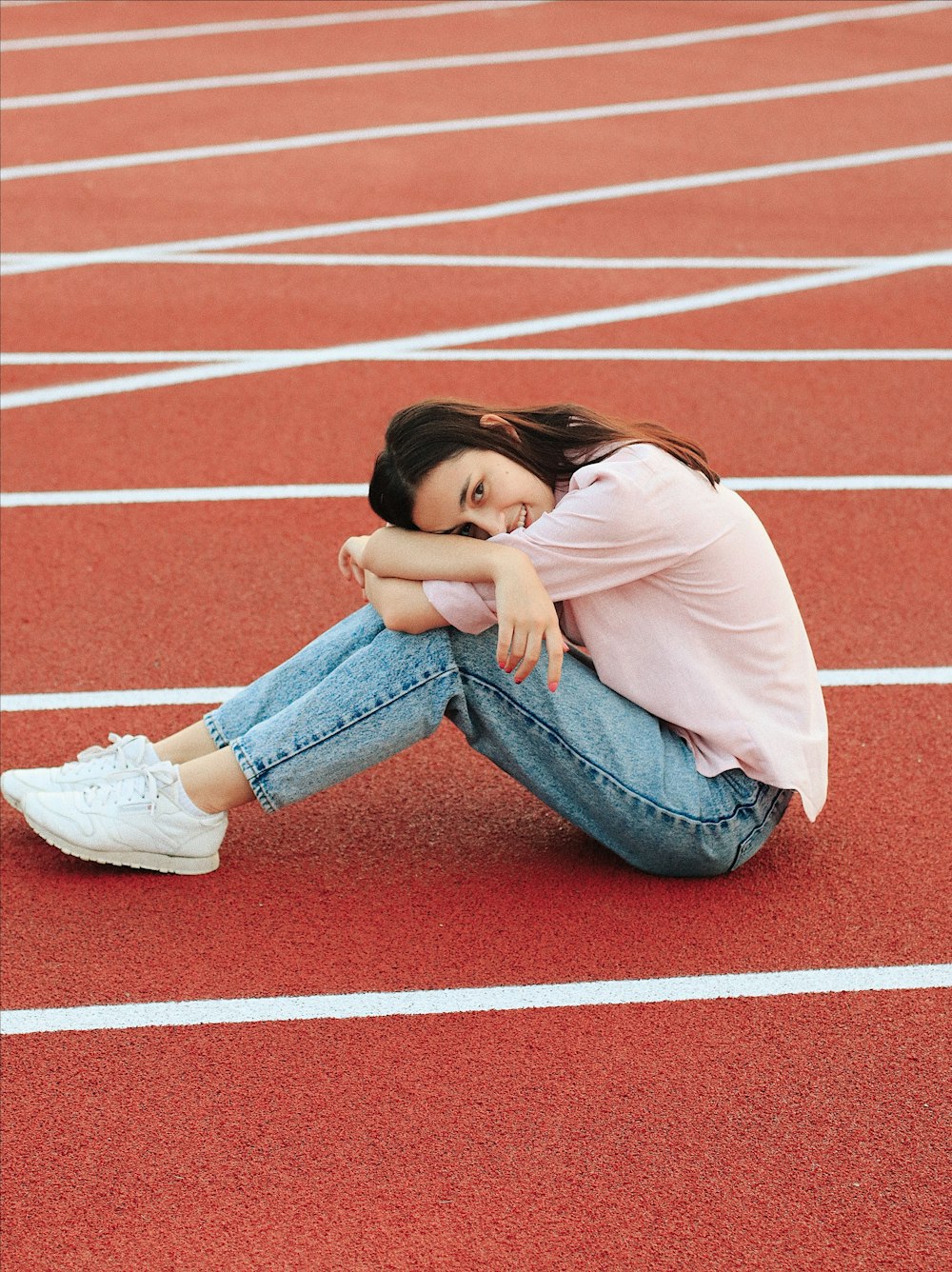 Donna che si siede sul campo di atletica