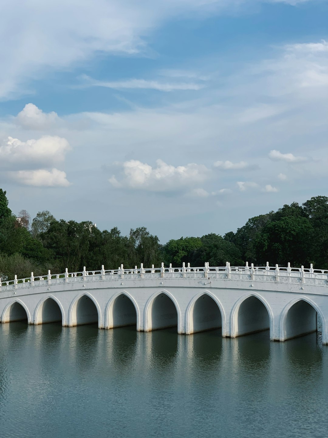 white painted bridge near green trees