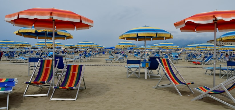 A cozy beach scene with a colorful poncho draped over a wooden chair near the shore.